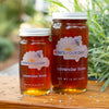 Raw local lavender rose infused honey from How's Your Day Honey in St. Petersburg FL, two jars 6oz, 12oz. Photographed on a cutting board with lavender flowers..
